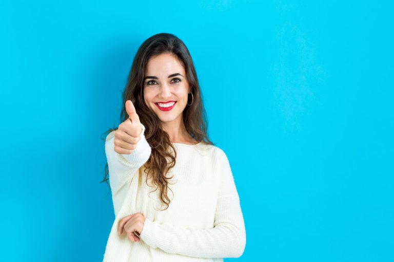 Happy young woman giving a thumb up